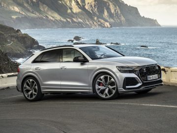 De Audi RS Q8 2019 rijdt op een weg vlakbij de oceaan.
