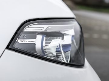 Een close-up van de koplamp van een witte BMW X7.