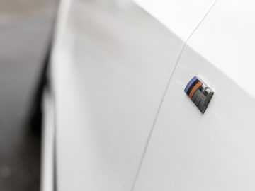 Een close-up van een BMW X7-badge op een witte auto.