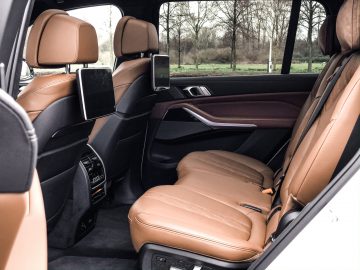 De achterbank van een BMW X7 met lederen stoelen.
