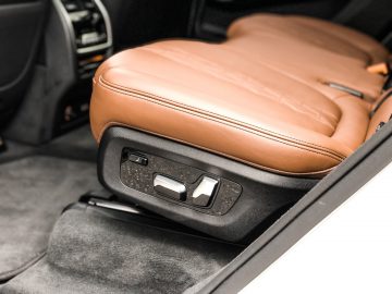 Het interieur van een BMW X7 met bruin lederen stoelen.