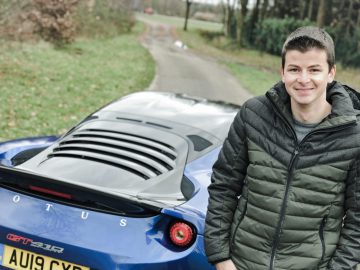 Een jonge man staat naast een blauwe sportwagen op AutoRAI.nl.