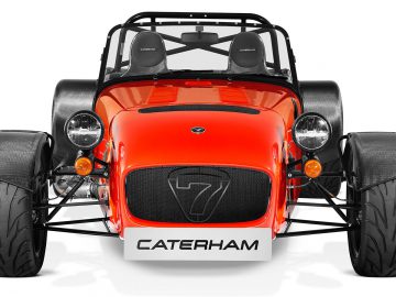 Een rode Caterham Seven 485 CSR op een witte achtergrond.