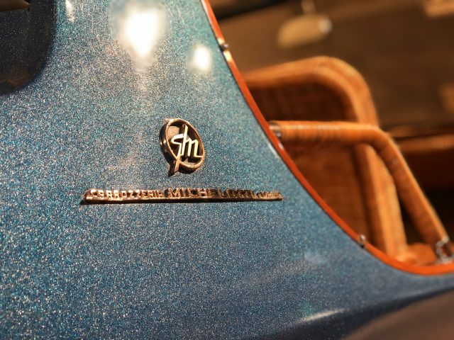 Een close-up van het embleem op een blauwe auto in het DAF Museum.