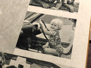Een foto van een klein meisje zittend in een auto in het DAF Museum.