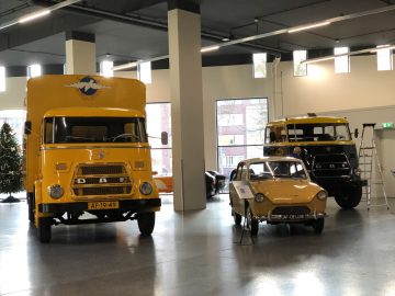 Een gele vrachtwagen geparkeerd in het gebouw van het DAF Museum.