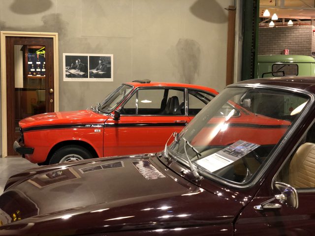 Een rood-zwarte auto geparkeerd in het DAF Museum.
