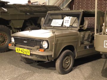Een groen militair voertuig tentoongesteld in het DAF Museum.