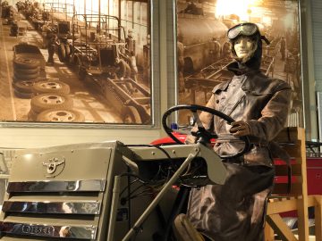 Een mannequin zittend in een auto in het DAF Museum.