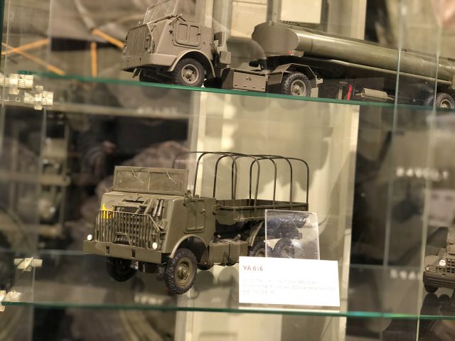 Een tentoonstelling van militaire voertuigen van DAF in een vitrinekast.