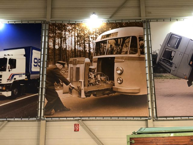 Een groep foto's van vrachtwagens uit het DAF Museum die in een gebouw hangen.