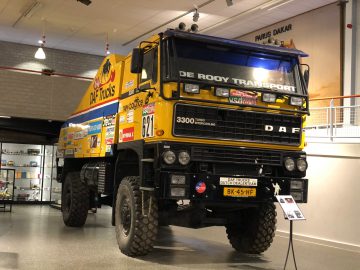 Een gele vrachtwagen te zien in het DAF Museum.
