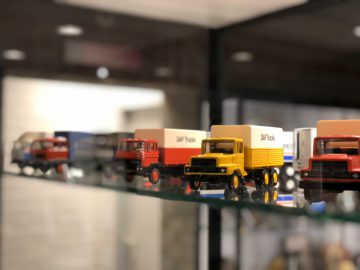 Een tentoonstelling van speelgoedvrachtwagens in de vitrine van het DAF Museum.