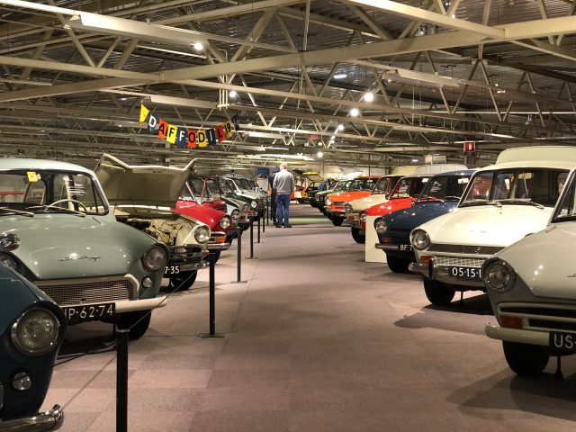 Een groep auto's in de garage van het DAF Museum.
