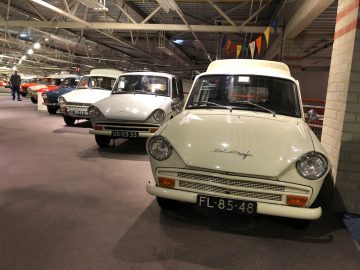 Een groep klassieke auto's geparkeerd in het DAF Museum.