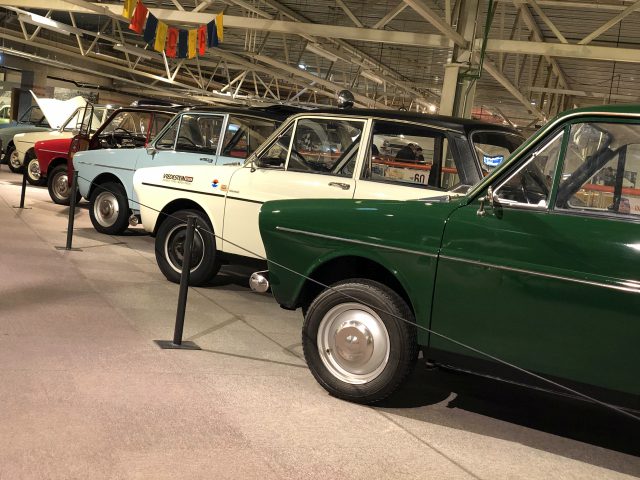 Een rij groen-witte auto's in het DAF Museum.