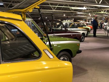 In de garage van het DAF Museum staat een gele auto geparkeerd.