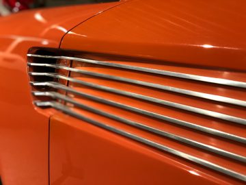 Een close-up van de grille van een oranje auto in het DAF Museum.