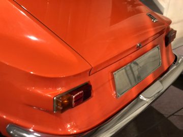 De achterkant van een oranje auto die te zien is in het DAF Museum.