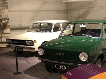 Twee groen-witte auto's tentoongesteld in het DAF Museum.