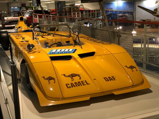 Een gele raceauto tentoongesteld in het DAF Museum.