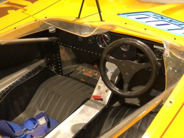 Het interieur van een gele raceauto, onderdeel van de collectie van het DAF Museum.