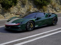 Een groene Ferrari SF90 Stradale-sportwagen die over een bergweg rijdt.