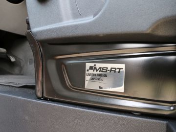Een close-up van het interieur van een Ford Transit Custom met een MS-RT limited edition-badge met een lege ruimte voor een serienummer.