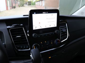 Middenconsole van een moderne Ford Transit Custom MS-RT met een infotainment-touchscreen en klimaatregeling.