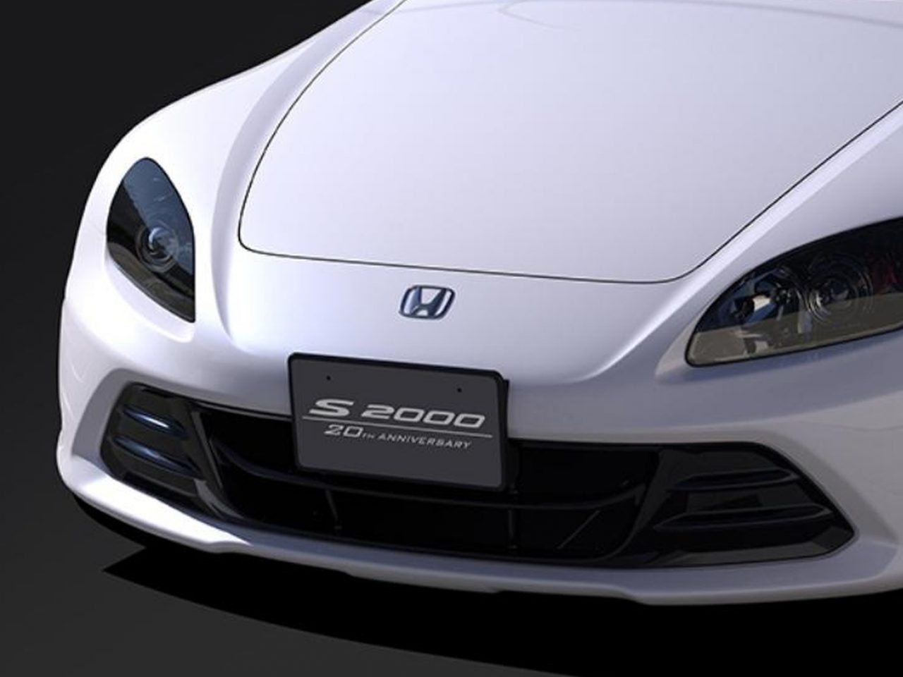 De voorkant van een witte Honda S2000-sportwagen.