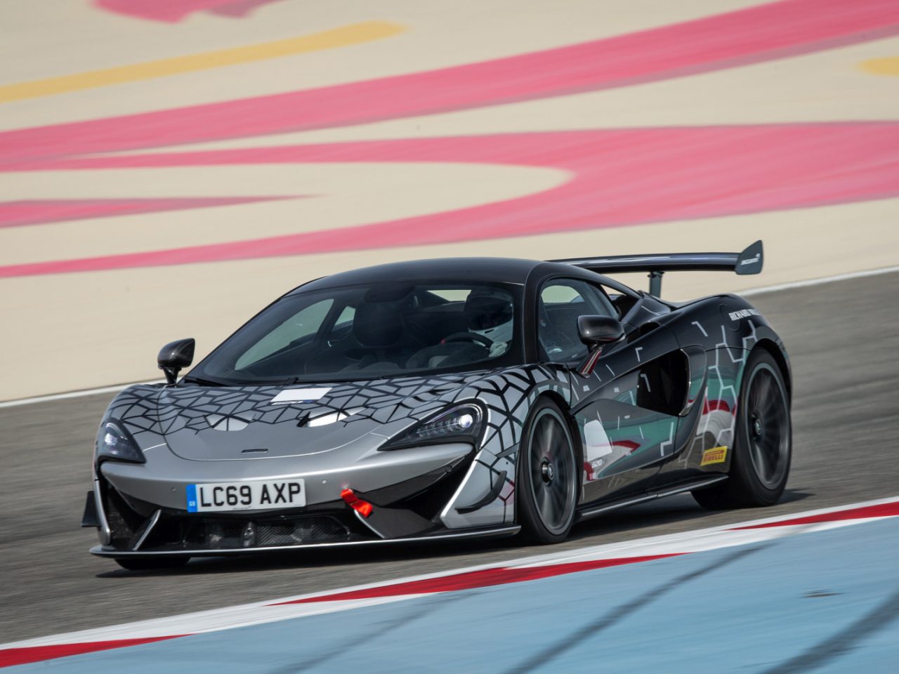 Een McLaren 620R-sportwagen die op een racecircuit rijdt.