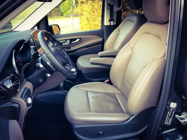 Het interieur van een Mercedes-Benz V-Klasse SUV met lederen stoelen en stuurwiel.