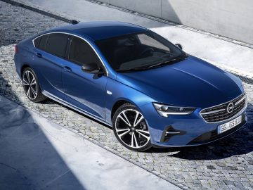 De Opel Insignia 2019 staat geparkeerd in een geplaveide straat.