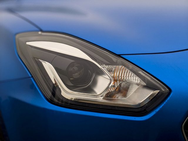 De koplamp van een blauwe Suzuki Swift-sportwagen.