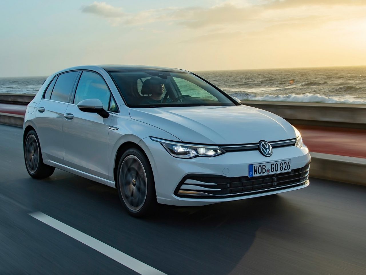 De Volkswagen Golf 8 GTI rijdt op een weg vlakbij de oceaan.