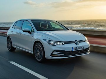 De Volkswagen Golf 8 GTI rijdt op een weg vlakbij de oceaan.