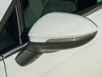 De achteruitkijkspiegel van een witte Volkswagen Golf 8.