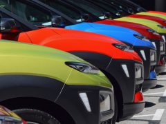 Een rij kleurrijke elektrische auto's uit het A-segment geparkeerd op een parkeerplaats.