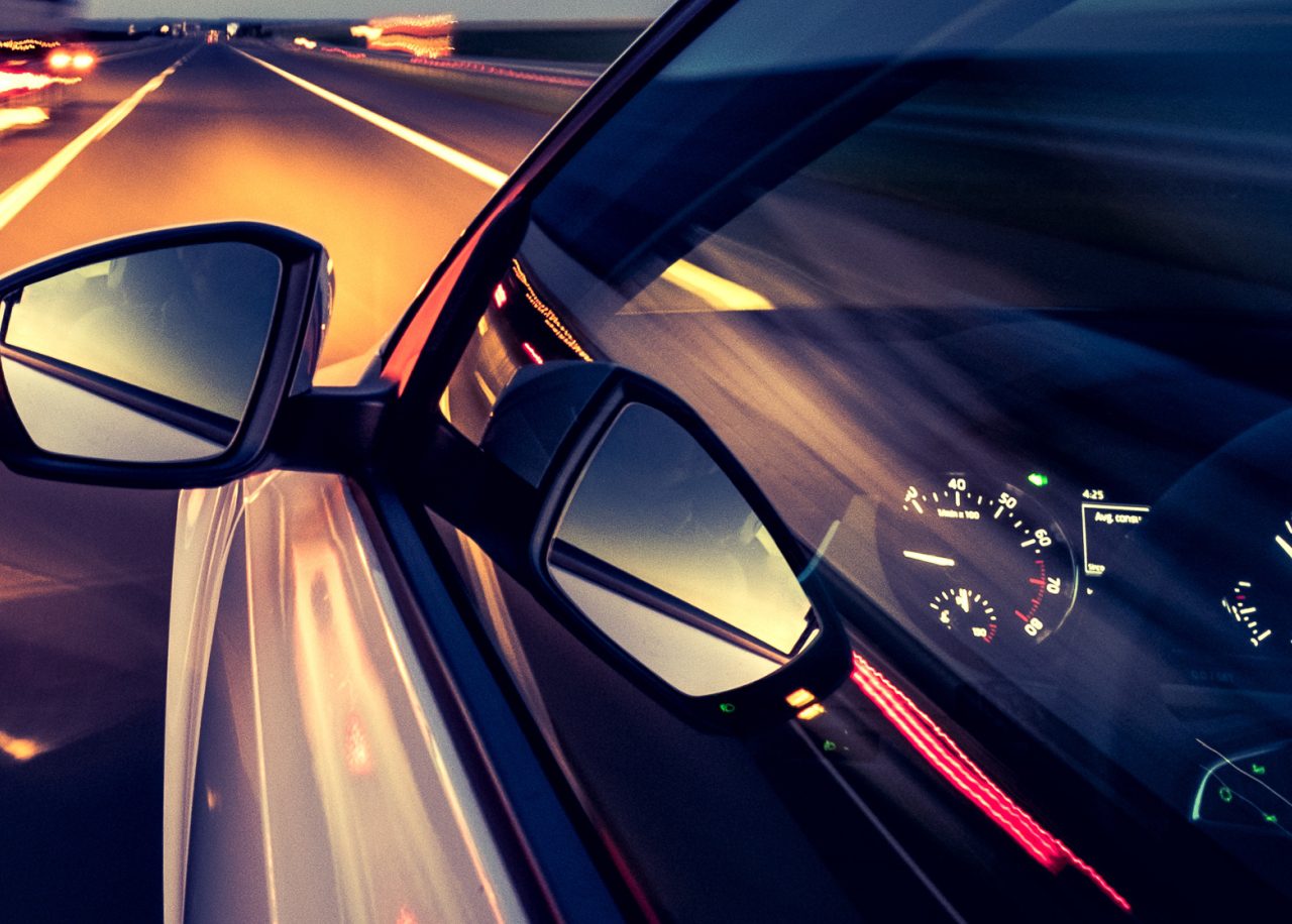 Een auto die 's nachts op een snelweg rijdt met een snelheid van 100.