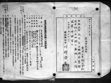 Een open boek met pagina's met traditionele Chinese of Japanse tekst naast een sierlijk Mazda-logo in een rechthoekige rand.
