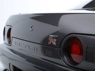 Close-up van het achterembleem en het achterlicht van een Nissan Skyline GT-R uit The Fast and the Furious.