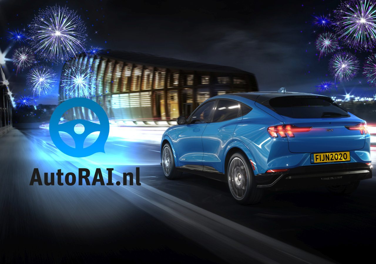 Een blauwe SUV, model autojaar 2020, rijdt over de weg met vuurwerk op de achtergrond.
