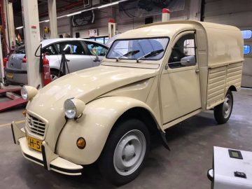 Vintage crèmekleurige Citroën bestelwagen in een werkplaats.