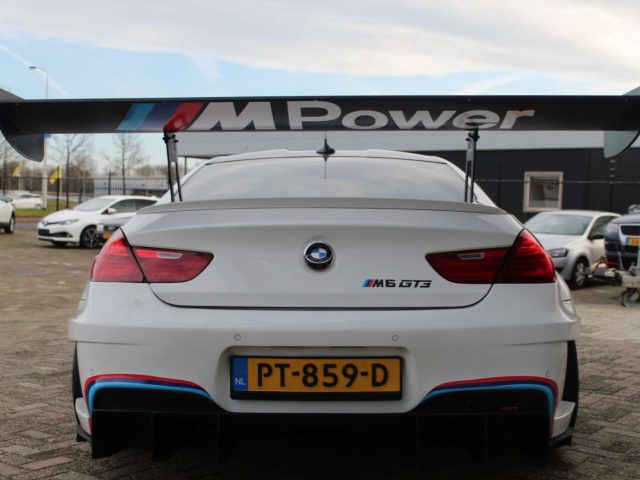 Achteraanzicht van een BMW M6 GT3 met een prominente vleugelspoiler met het M Power-logo.