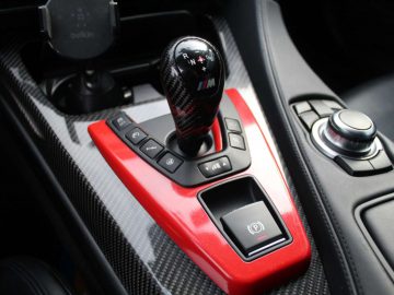 Een close-up van een versnellingspook uit de BMW M6 GT3-serie en de omliggende bedieningselementen.