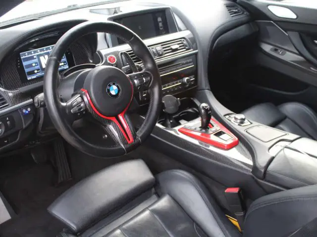 Interieur van een BMW M6 GT3-voertuig met de nadruk op het stuur en de middenconsole.