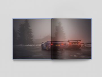 Een sportwagen, The Last Bugatti Racing Cars, geparkeerd op een mistige bergweg in de schemering, gezien door een open boek.