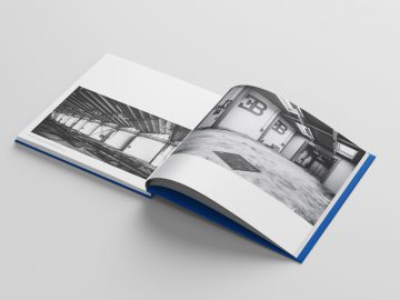 Open boek met harde kaft met een zwart-witfoto van The Last Bugatti Racing Cars, gedrukt over twee pagina's op een wit oppervlak.