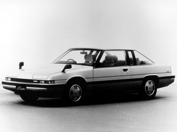 Een vintage Mazda tweedeurs coupé met opklapbare koplampen en een schuin achterprofiel.