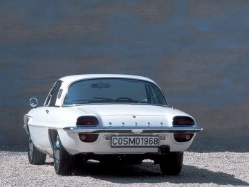 Klassieke Mazda-sportwagen uit 1968 met opvallende ronde achterlichten geparkeerd op een grindoppervlak.